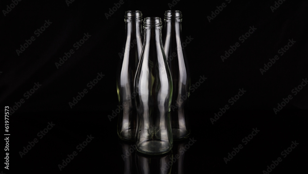 Empty bottles over black background