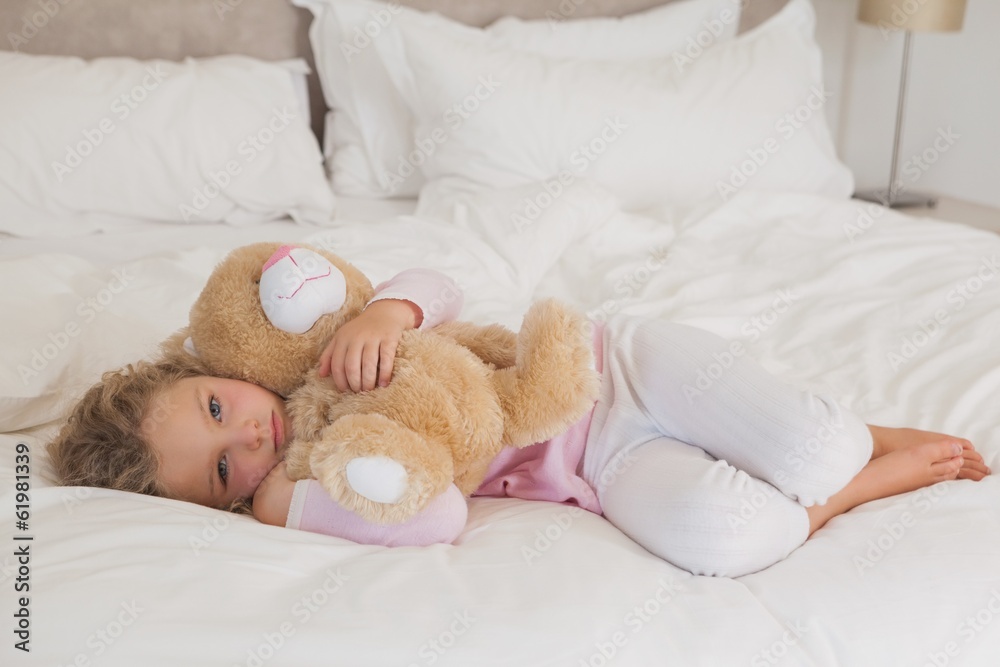 Young girl with stuffed toy resting in bed Young girl with stuffed toy resting in bed