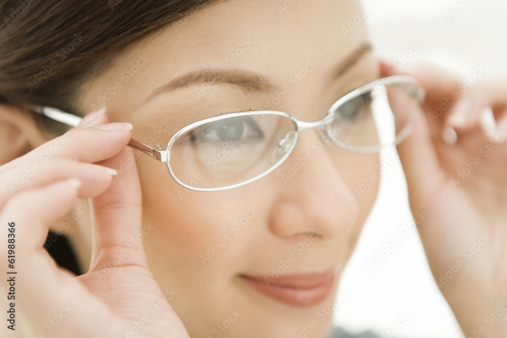 © TAGSTOCK2 - woman putting on glasses