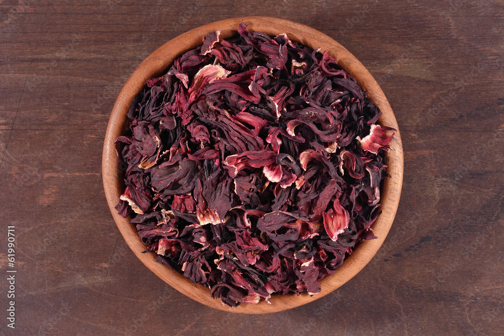 Dried petals of hibiscus in a wooden bowl Dried petals of hibiscus in a wooden bowl