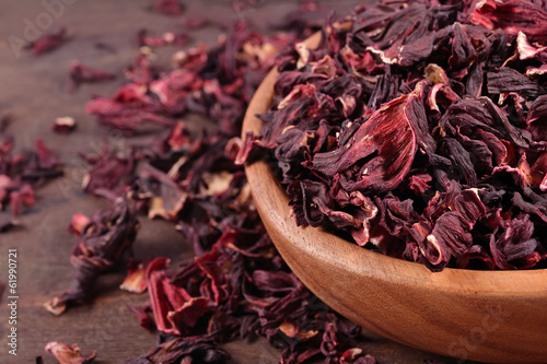 Dried petals of hibiscus in a wooden bowl photo
