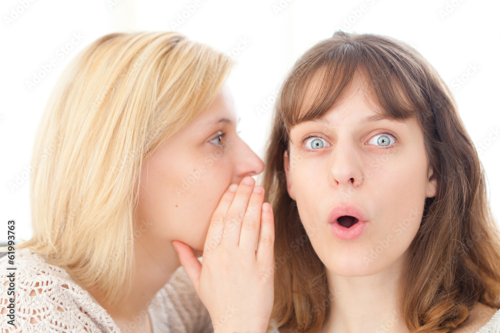 Blonde girl telling a secret to her best friend Blonde girl telling a secret to her best friend