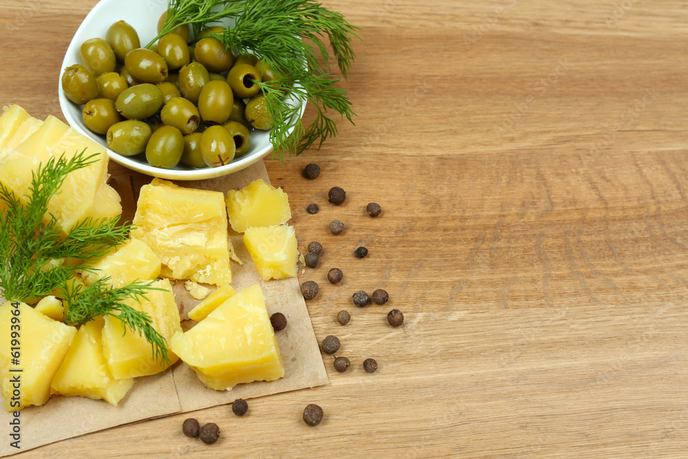 Parmesan cheese, fresh herbs and olives on wooden background Parmesan cheese, fresh herbs and olives on wooden background