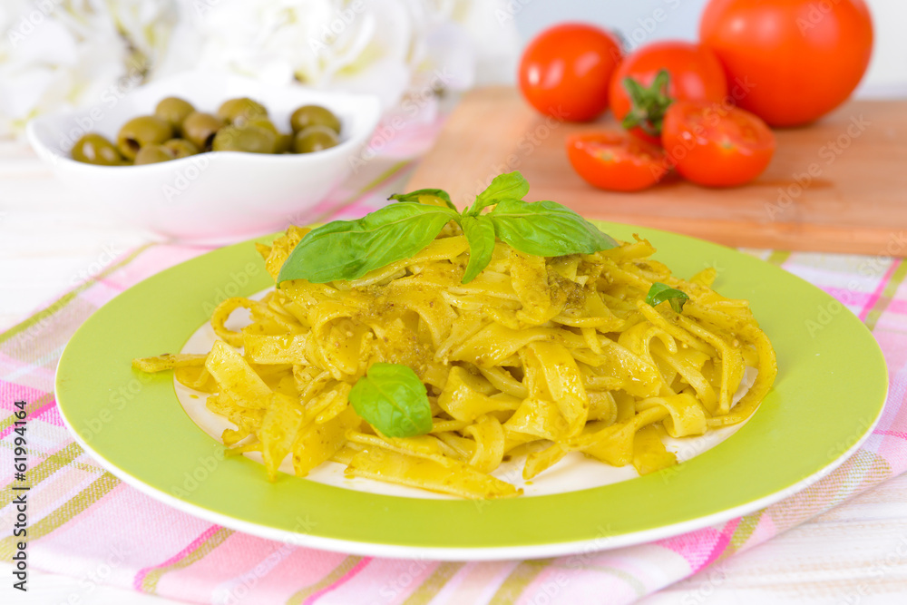 Delicious pasta with pesto on plate on table close-up