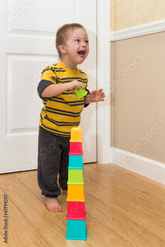 фотографія Down Syndrome child playing with stacking toy