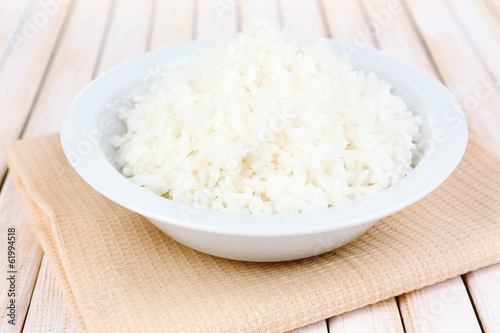 Cooked rice in bowl on wooden background