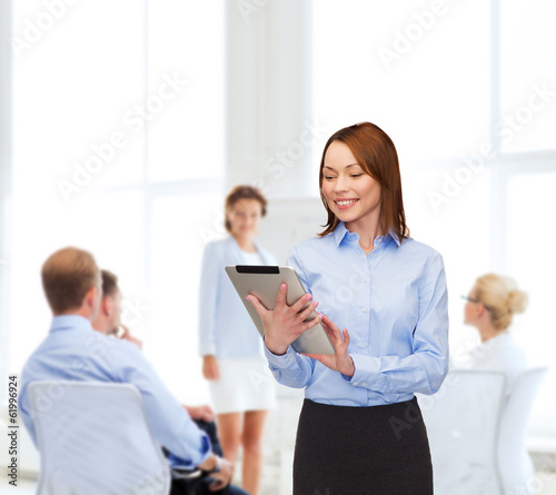 smiling woman looking at tablet pc at office