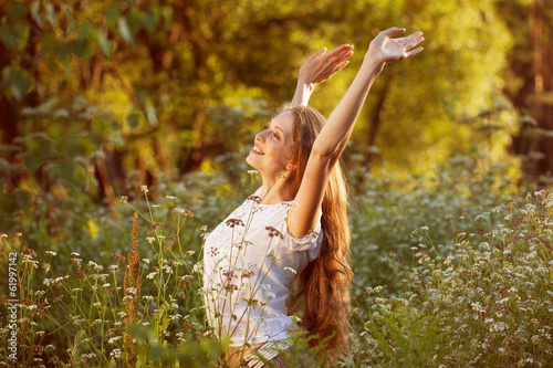 Schilderij op canvas Happy young woman among the wildflowers