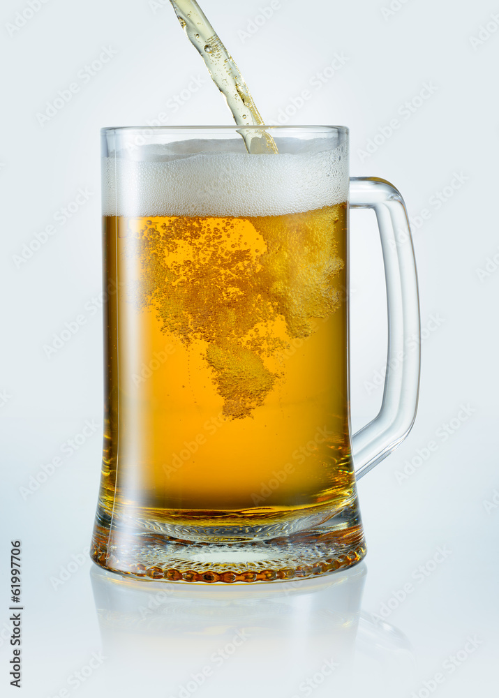 Beer is pouring into mug. With clipping path Beer is pouring into mug. With clipping path