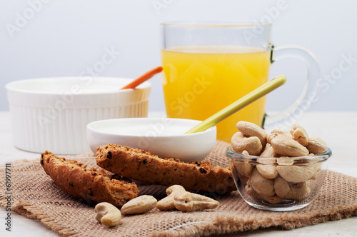 Orange juice and two bowls with bread and nuts