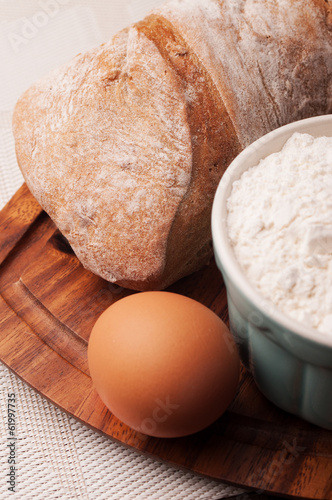 A bread loaf with flour and an egg