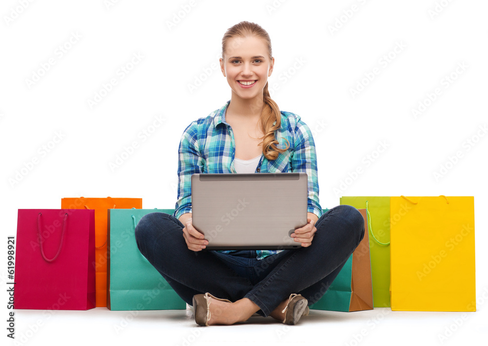 smiling girl with laptop comuter and shopping bags smiling girl with laptop comuter and shopping bags