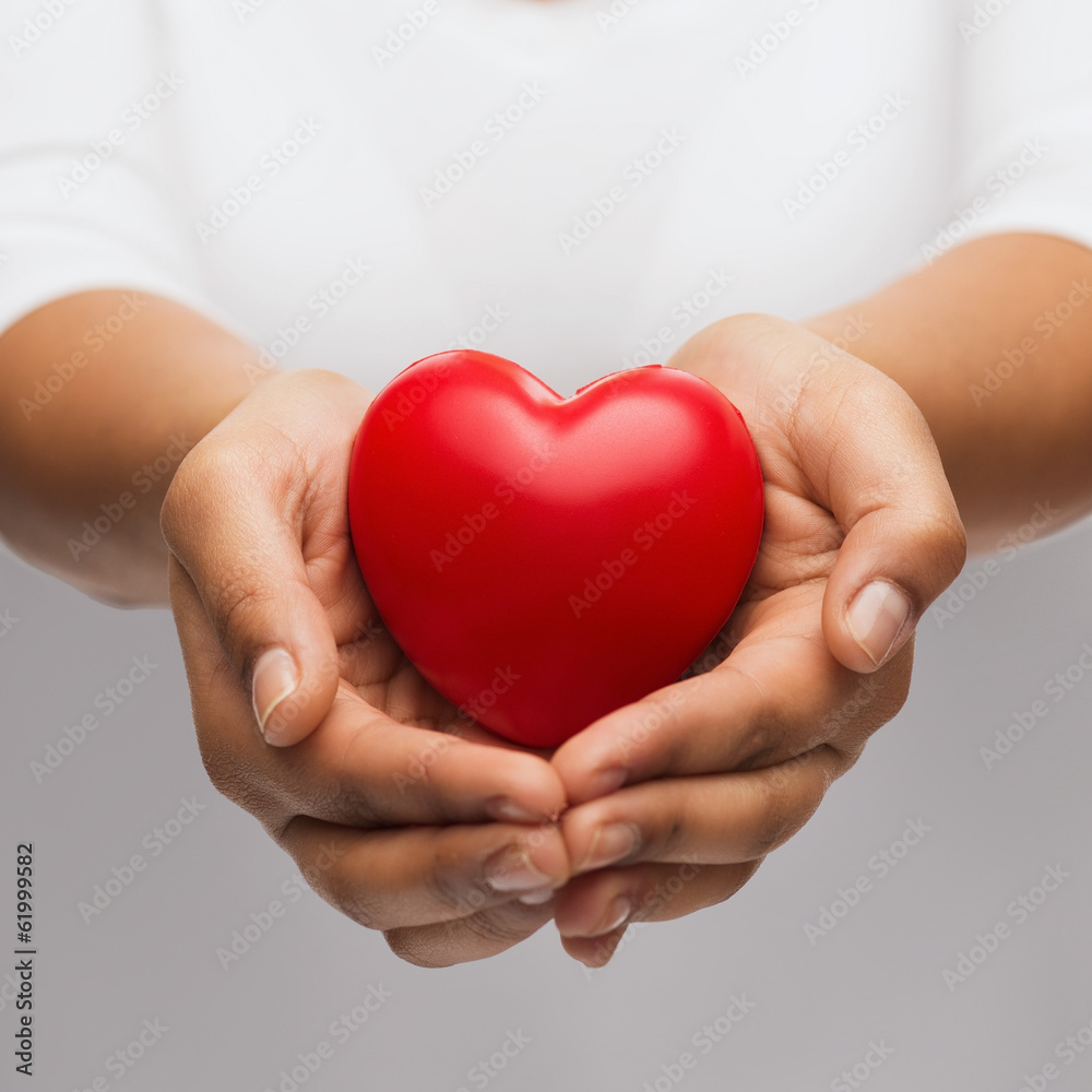 womans cupped hands showing red heart womans cupped hands showing red heart