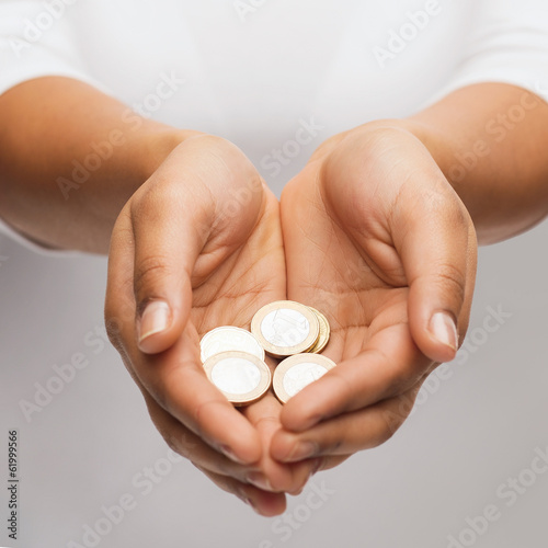 womans cupped hands showing euro coins