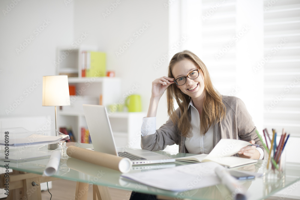 beautiful young woman sitting at her desk in the workplace beautiful young woman sitting at her desk in the workplace