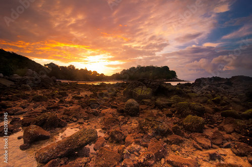 Sunset at tropical beach with rocks and stones