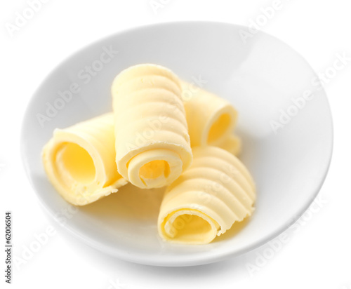 Curls of fresh butter in bowl, isolated on white