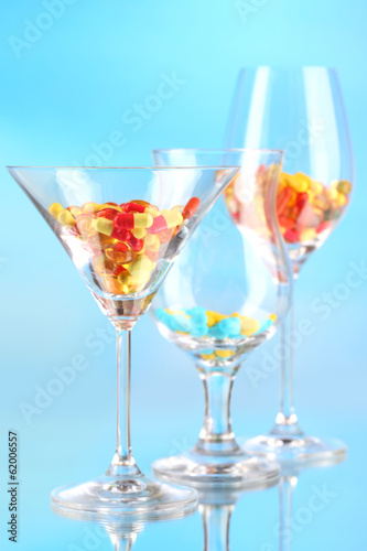 Goblets with pills on blue background