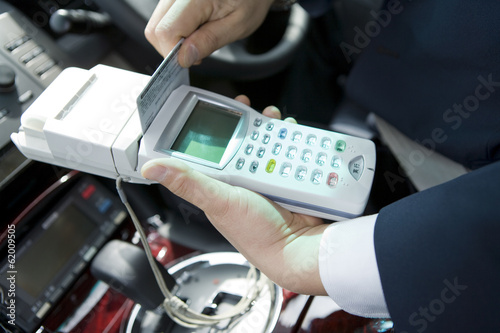 hand of taxi driver paying fo fares by credit card