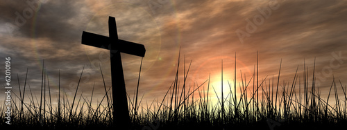 Obraz na plátne Black cross in grass at sunset