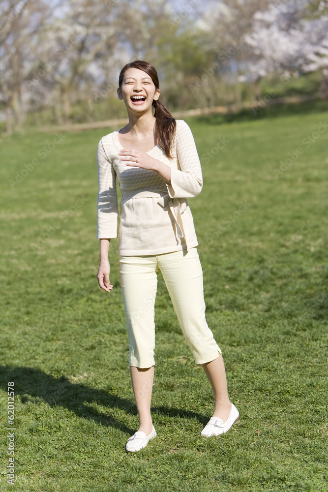 smiling woman standing still on lawn smiling woman standing still on lawn
