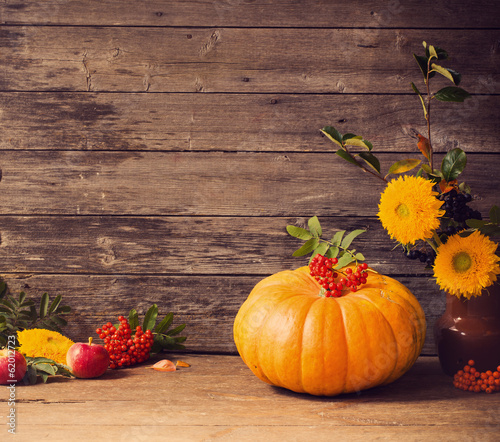 pumpkin with berries on wooden background