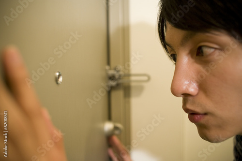 man looking into peep window photo