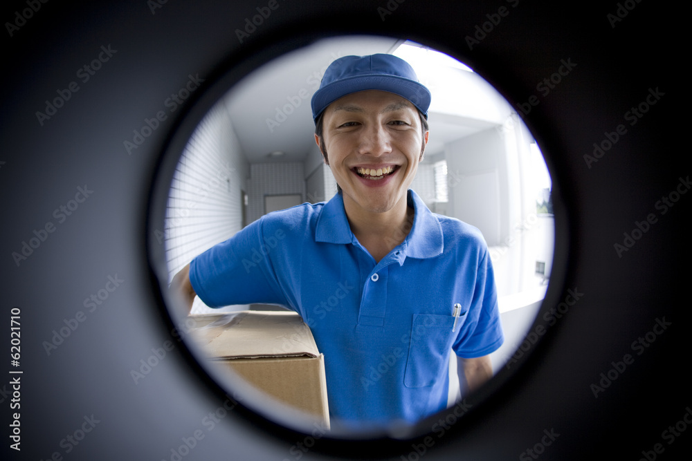 delivery person seen through peep window - obrazy, fototapety, plakaty 