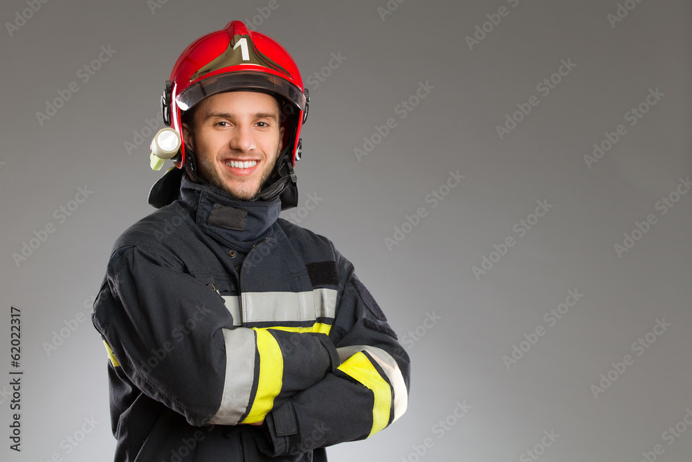 Naklejka premium Cheerful firefighter with crossed arms.
