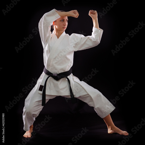 Tableau sur toile karate girl with black belt posing, champion of the world, on bl