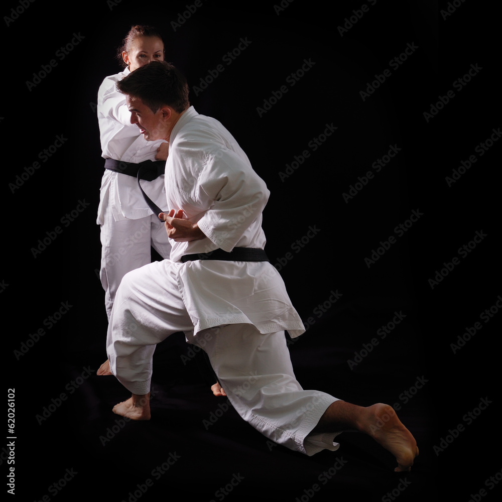 fighting karate couple, man and woman with black belts - champio fighting karate couple, man and woman with black belts - champio