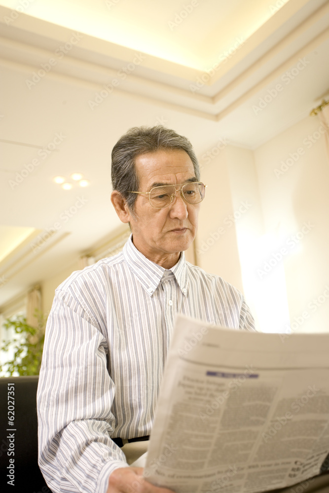 Naklejka premium senior man reading newspaper