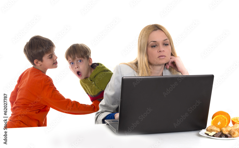 busy working mother with computer while her sons are fighting busy working mother with computer while her sons are fighting