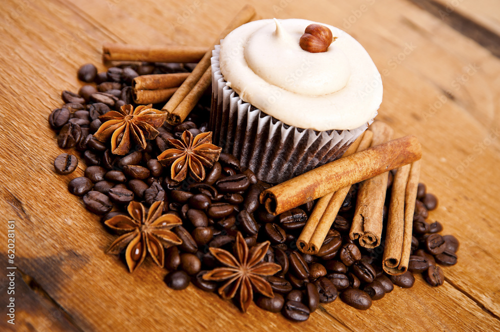 chocolate cupcake, coffee beans, cinnamon, star anise on sacking chocolate cupcake, coffee beans, cinnamon, star anise on sacking