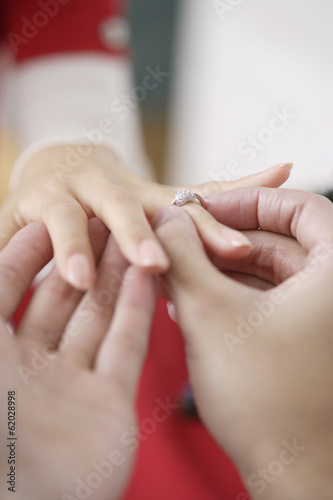 man putting a ring on woman s hand