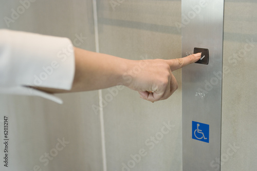 hand of pressing button of an elevator