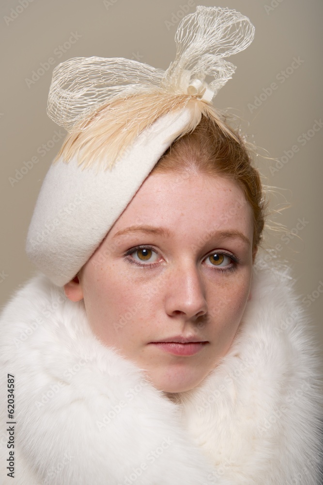 Redhead serious in white hat with bow and fur Redhead serious in white hat with bow and fur