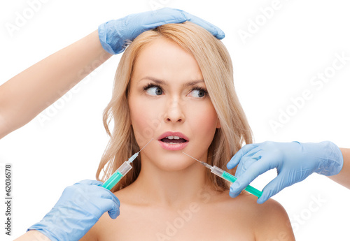 woman face and beautician hands with syringes photo