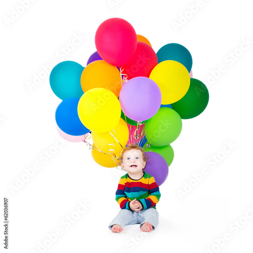 Funny baby girl playing with birthday balloons