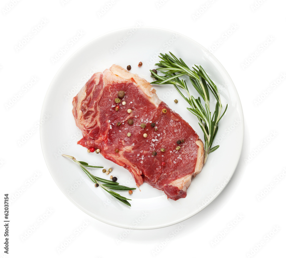 Raw sirloin steak with rosemary and spices on plate