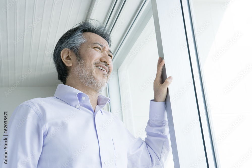 Fototapeta premium man looking out window
