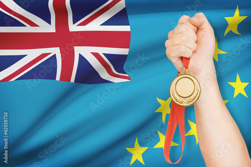 Medal in hand with flag on background - Tuvalu