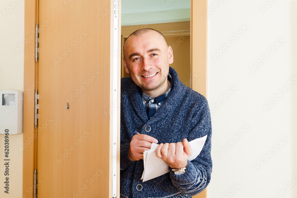 Happy man with papers near opens  door