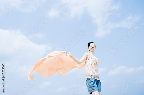 woman having cloth flutter under blue sky