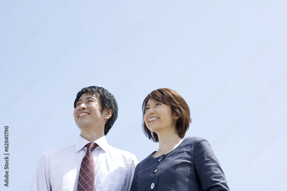 man and woman smiling with their back against blue sea man and woman smiling with their back against blue sea