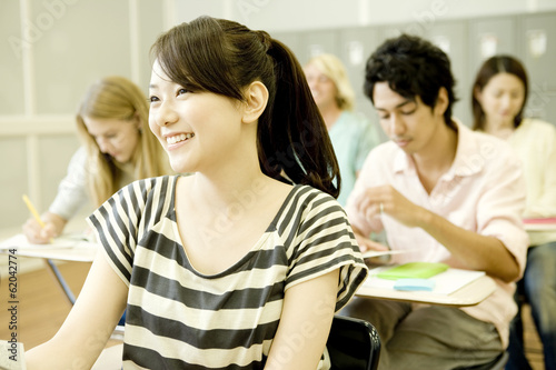 smiling female student studying in classroom