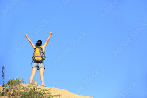 cheering hiking woman open arms desert mountain peak