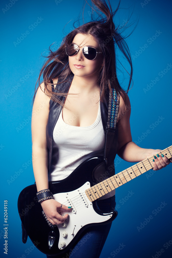 beautiful young woman wearing sunglasses with guitar