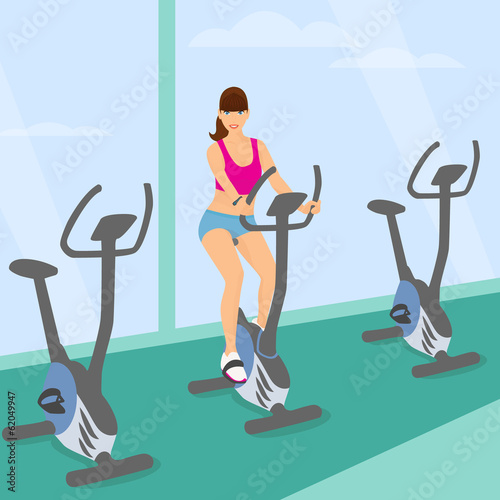 Young woman uses a bicycle in the gym for a good mood