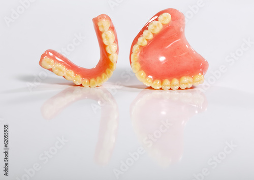 A set of dentures on a shiny white background